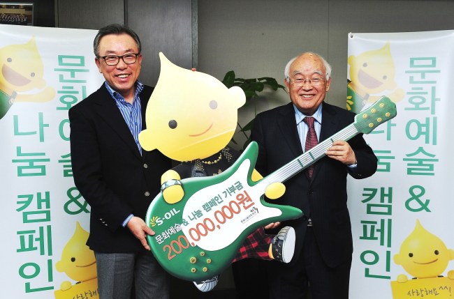 S-Oil chief financial officer Cho Young-il awards 200 million won ($179,000) to Pyo Jae-soon, head of culture sharing network SIROO, to support art and culture in the local community at the refiner’s headquarters in Seoul on Monday.   S-Oil