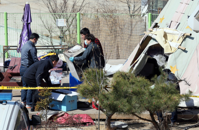 Police investigating Sunday’s deadly campsite fire confiscate items found at the scene, located near a beach on Ganghwado Island, Incheon, Monday.   Yonhap