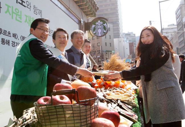 Starbucks Korea CEO Lee Seock-koo (left), Gyeonggi Gov. Nam Kyung-pil (second from left) and others campaign to promote homegrown agricultural products from the province on Tuesday in central Seoul after signing a pact, under which Starbucks will donate a portion of sales profits from products made with Gyeonggi farm products to the Mideum Agricultural Cooperative.   Starbucks Korea