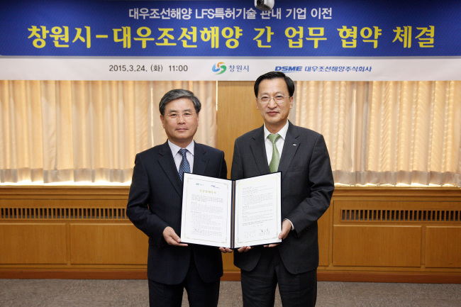 DSME senior managing director Um Hang-sub (right) poses with Changwon Vice Mayor Park Jay-hyun after signing an MOU on business cooperation on Tuesday.   DSME