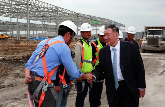 Hyundai Motor chairman Chung Mong-koo (right) encourages workers at the construction site for Kia’s new plant in Monterrey, Mexico, during his on-site trip on Thursday.   Hyundai Motor