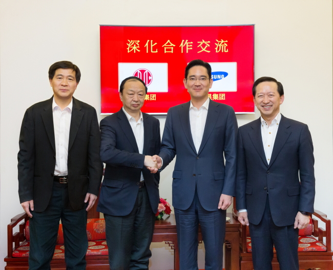 Samsung Electronics vice chairman Lee Jay-yong (second from right) shakes hands with Citic Group chairman Chang Zhenming at the Chinese group’s headquarters in Beijing on Wednesday.   Samsung
