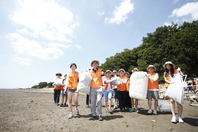 Hanwha Life executives and students participate in a cleanup campaign on Ganghwado Island.   Hanwha Life