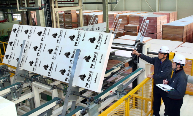 LG Hausys employees make a final inspection of phenolic foam panels at its factory in Chungju on Friday.   LG Hausys