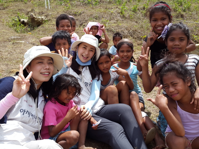 Asiana Airlines employees smile with local Aeta children at Pilien Village in the Philippines. Employees from the airline visited the village over the weekend to do volunteer work and to share Korean culture. Asiana Airlines has been providing the indigenous Aeta tribe with sanitation and construction support since 2009.   Asiana Airlines