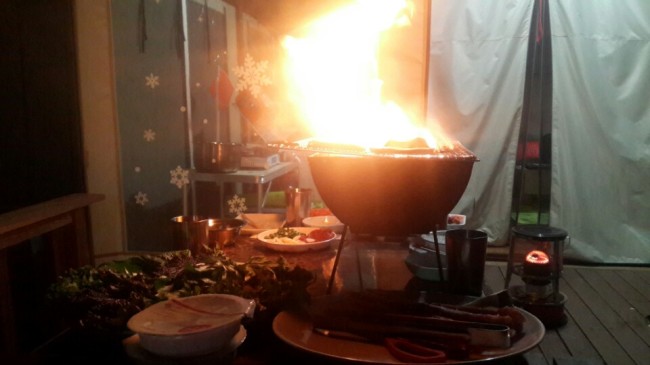 글램핑장 텐트 바로 앞 나무데크에서 바베큐를 하는 모습. 가연성 소재 텐트에 불이 옮겨붙을 위험이 크다.
