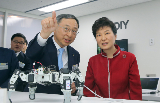 KT chairman Hwang Chang-gyu (left) explains about a robotic spider based on Internet of Things technology to President Park Geun-hye at the newly opened Center for Creative Economy and Innovation in Gyeonggi Province on Monday. Yonhap