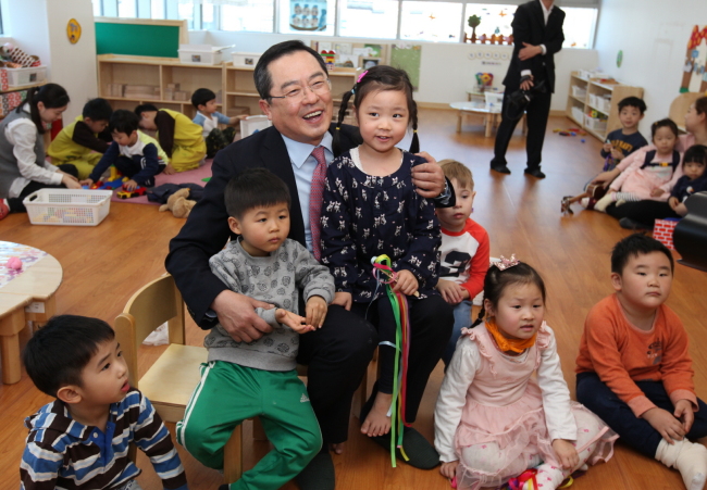 LS Group chairman Koo Ja-yol (center) poses with children at the LS day care center.   LS Group