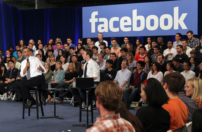 President Barack Obama meets with Mark Zuckerberg at the
Facebook office in front of a crowd.