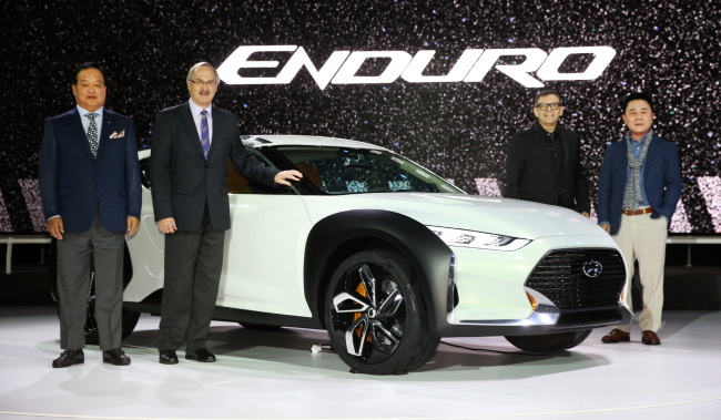 From left: Hyundai Motor president Kim Choong-ho, Korean national football squad coach Uli Stielike, Kia Motors president Peter Schreyer and Hyundai executive vice president Kwak Jin pose with Hyundai’s concept car Enduro on Thursday at the media preview for the 2015 Seoul Motor Show.   Hyundai Motor