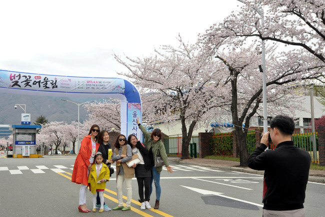 Visitors to Samsung SDI’s plant pose during the firm’s cherry blossom event in Ulsan on Saturday. The battery-maker recently opened its internal workplace to some 2,000 family members of employees and
residents in the city.    Samsung SDI