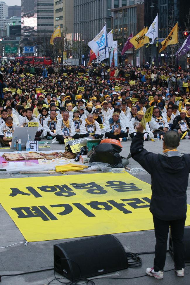 Families of those killed in the Sewol ferry disaster hold a rally in Seoul, Sunday. They demanded the government rewrite the mandate on investigating the cause and measures related to the disaster. (Yonhap)