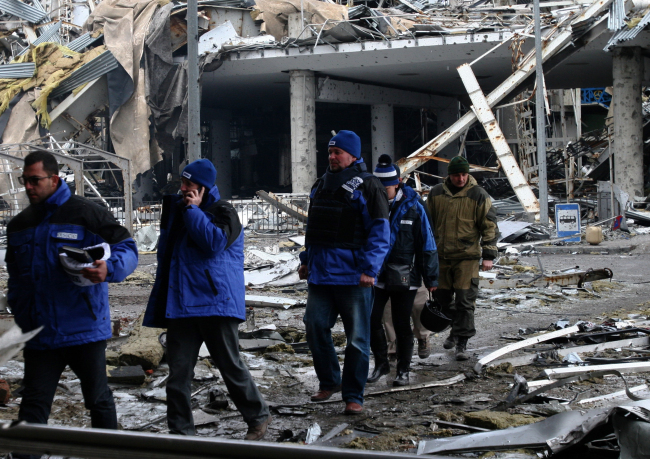 Organization for Security and Cooperation in Europe representatives inspect the area around Donetsk Airport on Saturday.   TASS-Yonhap