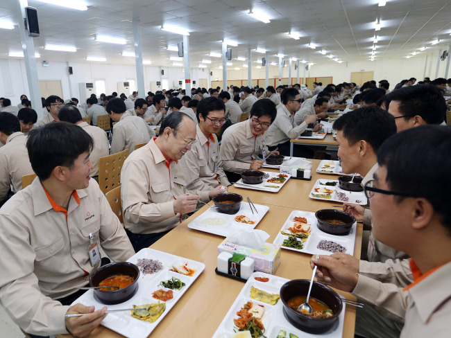 Hanwha Group chairman Kim Seung-yeon talks to employees while having lunch at the base camp of the company’s construction site in Bismayah, Iraq.    Hanwha E&C