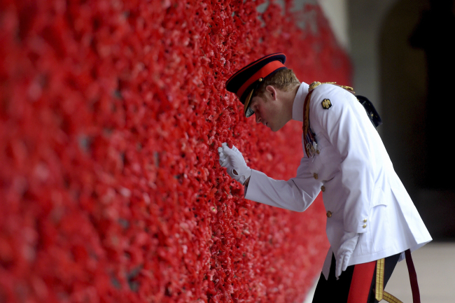 <YONHAP PHOTO-0666> Britain's Prince Harry places a poppy at the Roll of Honour during a visit to the Australian War Memorial in Canberra, Australia, Monday, April 6, 2015. Prince Harry, or Captain Harry Wales as he is known in the British Army, will end his military career with a month long assignment with the Australian Defense Force in barracks in Sydney, Perth and Darwin. (AP Photo/Lukas Coch, Pool)/2015-04-06 09:33:03/ <저작권자 ⓒ 1980-2015 ㈜연합뉴스. 무단 전재 재배포 금지.>
Britain’s Prince Harry places a poppy at the Roll of Honor during a visit to the Australian War Memorial in Canberra, Australia, Monday. Prince Harry, or Captain Harry Wales as he is known in the British Army, will end his military career with a monthlong assignment with the Australian Defense Force in barracks in Sydney, Perth and Darwin. (Related story on Page 18)     AP-Yonhap
