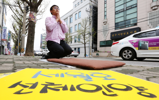 A citizen bows in respect to the 304 lost lives from the Sewol ferry sinking in April last year in front of the Gwangju High Court on Tuesday. A final trial on appeal was due at the court on the captain and crew of the ship, who have been convicted of negligence.   Yonhap