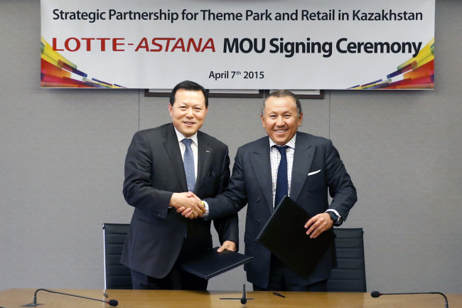 Lotte Corp. president Hwang Kak-gyu (left) shakes hands with Astana Group president Nurlan Smagulov during an MOU signing ceremony in Seoul on Wednesday. Lotte Group