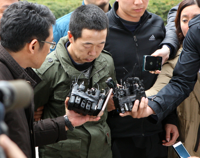 Kim Ha-il, the supect in the Siheung murder, is escorted into the Siheung Police Station in Gyeonggi Province on Monday. Yonhap