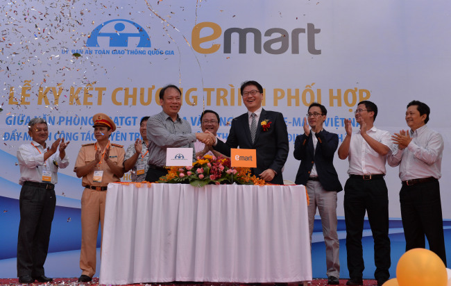 Choi Gwang-ho (right), general director of E-mart Vietnam, shakes hands with Nguyen Trong Thai,  head of the Vietnam Traffic Safety Committee, after concluding an MOU at Nguyen Viet Xuan Elementary School in Ho Chi Minh City on Wednesday.   Yonhap