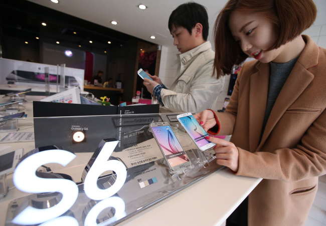 A customer checks out a Samsung Galaxy S6 Edge phone at a LG Uplus retail outlet in Jongno, central Seoul, on Friday. Samsung Electronics’ new flagship smartphones, the Galaxy S6 and S6 Edge, go on sale Friday worldwide.   Yonhap
A customer checks out a Samsung Galaxy S6 Edge phone at a LG Uplus retail outlet in Jongno, central Seoul, on Friday. Samsung Electronics’ new flagship smartphones, the Galaxy S6 and S6 Edge, go on sale Friday worldwide.   Yonhap