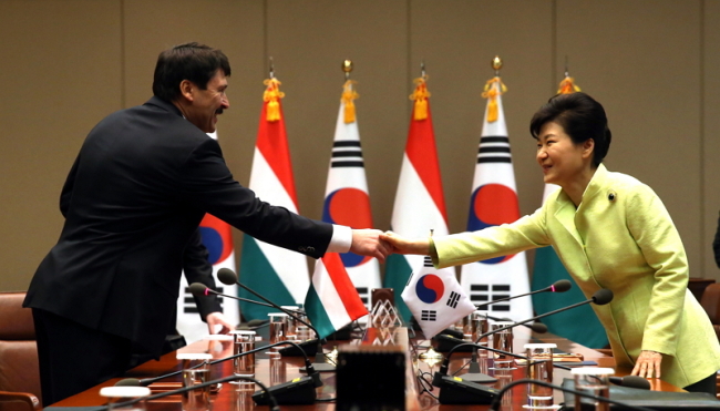 President Park Geun-hye (right) shakes hands with her Hungarian counterpart Janos Ader ahead of their summit on Tuesday at Cheong Wa Dae.   (Yonhap)
