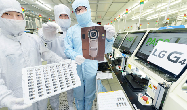 LG Innotek workers pose with a sheet of 16-megapixel camera modules, which will be used in LG Electronics’ new marquee smartphone G4.     LG Electronics