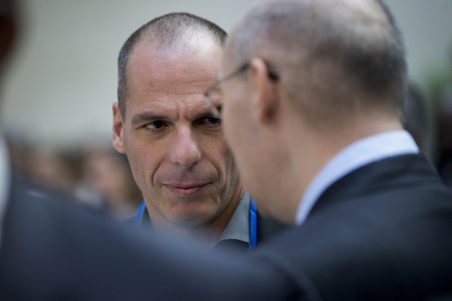 Yanis Varoufakis, Greece’s finance minister (left), talks to Kairat Kelimbetov, governor of the National Bank of Kazakhstan, before an IMF governors’ group photo during the IMF and World Bank Group Spring Meetings in Washington, D.C., Saturday.   Bloomberg
