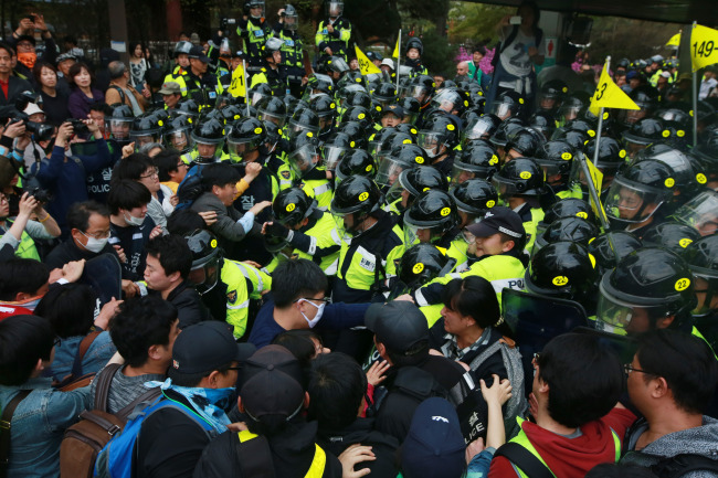 Supporters of the victims of the Sewol ferry sinking clash with police on Saturday as they march toward Gwanghwamun Square in Seoul.   Yonhap.