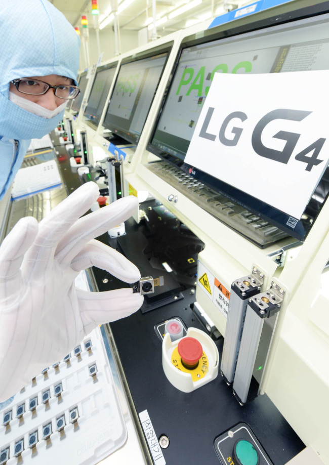 광주 LG이노텍 공장에서 G4에 들어갈 최첨단 카메라 모듈을 생산하는 모습. 0.0005㎜ 크기의 먼지 10개도 허용치 않는 무결점 ‘10존 클린룸’으로, 모든 작업자들은 방진복, 방진화 착용, 접착롤을 사용한 먼지 제거, 정전기 테스트, 방진화 바닥 세척, 에어샤워, 접착롤 다시 사용, 손 세척 등 7가지 위생 절차를 밟아야만 들어갈 수 있다.  [사진제공=LG이노텍]