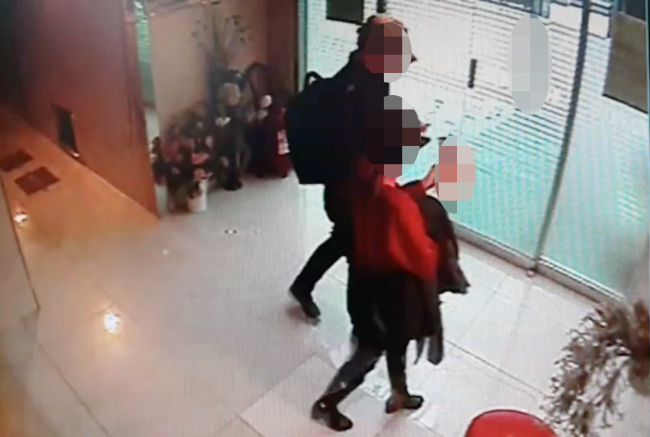 CCTV footage shows a murder suspect (left) and his teenage victim entering a motel in Seoul last month. The two reportedly met via a mobile messaging application for prostitution at the property, where the victim was later found dead.   Yonhap