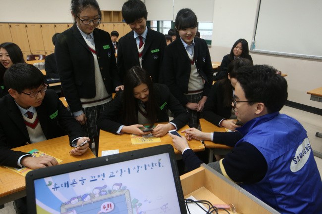 <YONHAP PHOTO-2577> 송파구, 청소년 스마트폰 중독 예방교육 실시 (서울=연합뉴스) 양지웅 기자 = 14일 오후 서울 송파구 장지동 문현중학교에서 학생들이 청소년 스마트폰 중독 예방교육을 받고 있다. 2015.4.14 yangdoo@yna.co.kr/2015-04-14 16:02:08/ <저작권자 ⓒ 1980-2015 ㈜연합뉴스. 무단 전재 재배포 금지.>
Students learn about the danger of Internet addiction at a middle school in Seoul. Yonhap