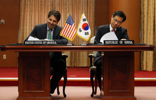 Korea’s chief negotiator Park Ro-byug (right) and U.S. Ambassador to Korea Mark Lippert make a preliminary signing for the civilian atomic energy accord at the Foreign Ministry in Seoul on Wednesday.    Yonhap