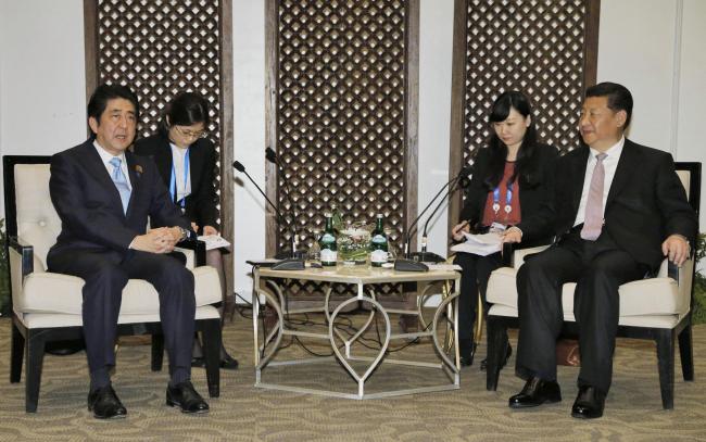Japan's Prime Minister Shinzo Abe (left) talks with China's President Xi Jinping (right) during a bilateral meeting on the sidelines of the Asian-African Conference in Jakarta on April 22. (Yonhap)