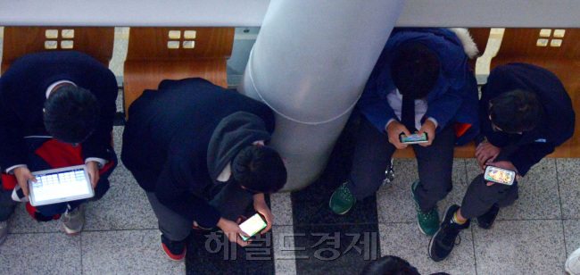 청소년 스마트폰 속 모바일 게임 중독 문제가 심각한 가운데 청소년들이 한 행사장에서 기다리리는 동안 게임을 하고 있다. 김명섭 기자/ msiron@heraldcorp.com
