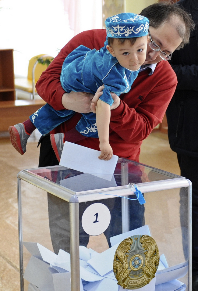 <YONHAP PHOTO-0060> A man helps his son to cast his ballot at a polling station in Astana, the capital of Kazakhstan, Sunday, April 26, 2015. Voters in Kazakhstan turned out in abundance at polling stations Sunday for a presidential election guaranteed to overwhelmingly reconfirm the 74-year-old incumbent, who has ruled over the former Soviet republic for more than 25 years. (AP Photo/Alexei Filippov)/2015-04-27 01:03:21/ <저작권자 ⓒ 1980-2015 ㈜연합뉴스. 무단 전재 재배포 금지.>
A man helps his son cast his ballot at a polling station in Astana, the capital of Kazakhstan, Sunday.   AP-Yonhap