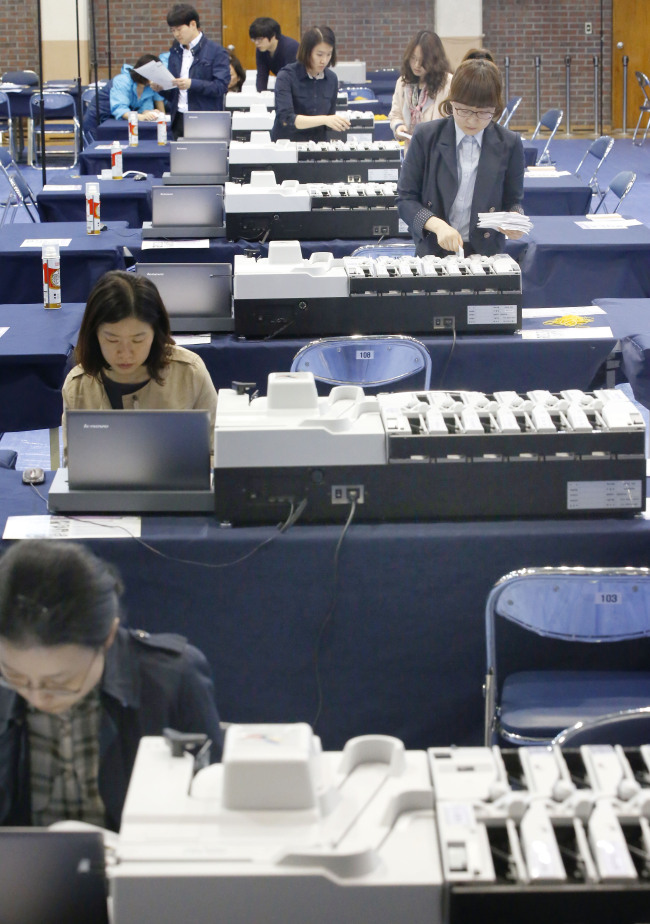 Election watchdog officials test ballot boxes at an elementary school in Gwanak-gu, Seoul, Tuesday. (Yonhap)