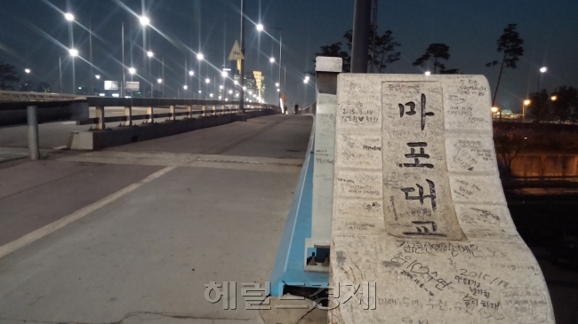 ‘자살다리’로 유명해진 마포대교가 어느새 커플들이 변치않는 사랑을 기약하는 성지(聖地)로 변모하고 있다. 마포대교 난간이나 표지석 등 곳곳에 연인들이 자신의 이름들 사이에 하트를 그려넣으며 애정을 기리는 글들이 빼곡히 차 있었다. 김명섭 기자/msiron@heraldcorp.com