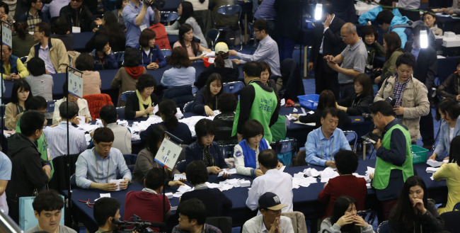 <YONHAP PHOTO-3343> 관악을 선거 향방은? (서울=연합뉴스) 홍해인 기자 = 4·29 재보선이 치러진 29일 저녁 서울 관악구 인헌초등학교에 마련된 개표소에서 개표 요원들이 투표 용지를 정리하고 있다. 2015.4.29 hihong@yna.co.kr/2015-04-29 21:14:47/ <저작권자 ⓒ 1980-2015 ㈜연합뉴스. 무단 전재 재배포 금지.>
Electoral officials count the votes in Seoul’s Gwanak district late Wednesday.   Yonhap
Electoral officials count the votes in Seoul’s Gwanak district late Wednesday.   Yonhap
