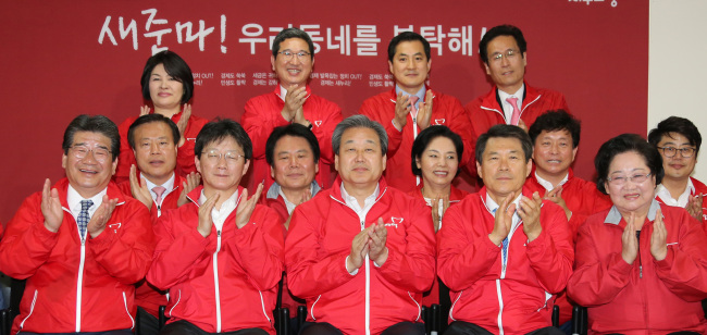Saenuri leader Kim Moo-sung (center) and floor leader Yoo Seung-min (second from left)applaud at the party's head office in Seoul on Wednesday. Yonhap