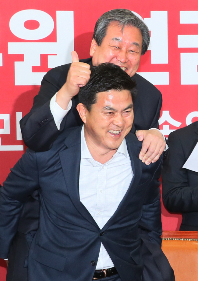Kim Tae-ho (front), a Supreme Council member of the ruling Saenuri Party, carries party leader Kim Moo-sung on his back during a party meeting in the National Assembly in Seoul on Thursday.    Yonhap
Kim Tae-ho (front), a Supreme Council member of the ruling Saenuri Party, carries party leader Kim Moo-sung on his back during a party meeting in the National Assembly in Seoul on Thursday.    Yonhap