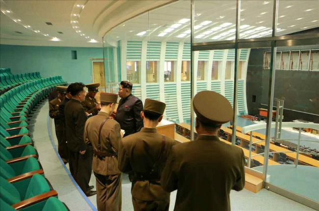 North Korean leader Kim Jong-un (third from right) speaks with officials during his visit to a newly built satellite control and command center.   Yonhap