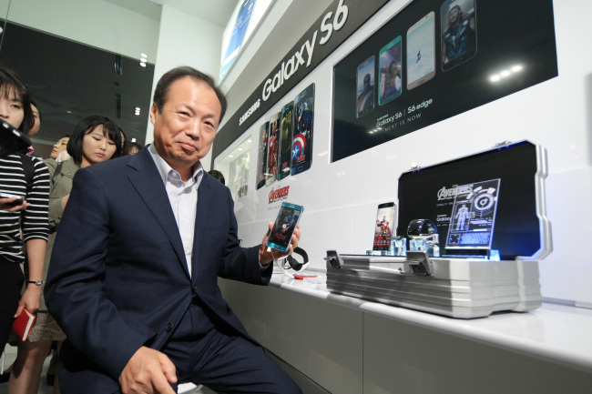 Samsung Electronics’ mobile business chief Shin Jong-kyun poses with some of the tech giant’s devices featured in the movie “Avengers: Age of Ultron,” at Coex in southern Seoul on Monday.    Samsung Electronics