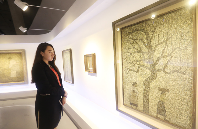 A visitor views a painting by Park Soo-keun at an exhibition at Dongdaemun Design Plaza.   Yonhap