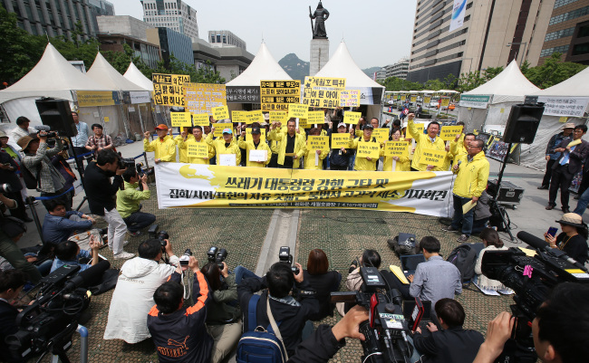 Bereaved families of victims in last year’s deadly ferry sinking hold a rally Wednesday against the ordinance for the investigation into the accident in Gwanghwamun Square, Seoul.   Yonhap
