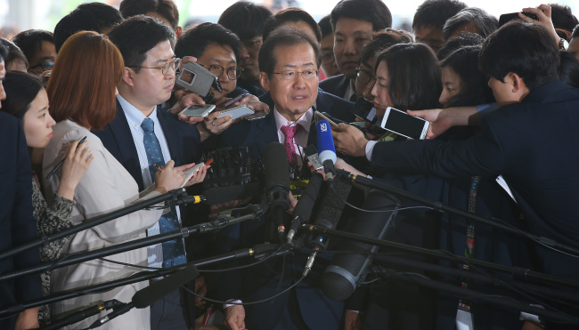 South Gyeongsang Province Gov. Hong Joon-pyo speaks to the press before entering the Seoul High Prosecutors’ Office for questioning over his alleged involvement in a graft scandal Friday.   Yonhap