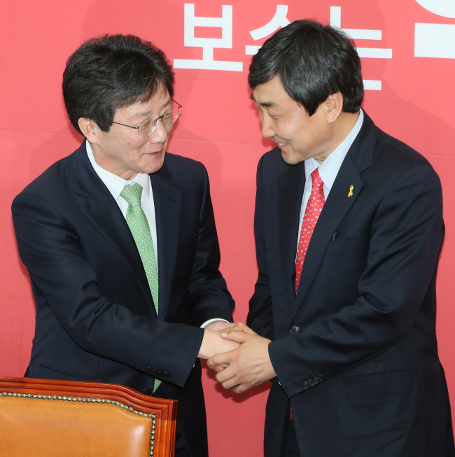 Saenuri Party Floor Leader Yoo Seung-min (left) shakes hands with Lee Jong-kul, newly-elected counterpart of New Politics Alliance for Democracy at the National Assembly, Seoul, Sunday. (Yonhap)