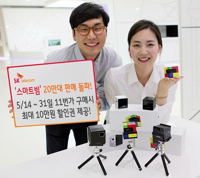 Models pose with SK Telecom Smart Beam pico projectors. SK Telecom