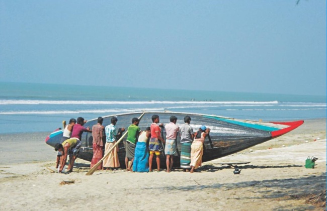 A group of people prepare a boat to sail from Khurer Mukh in Teknaf. This is one of the starting points of trafficking to Malaysia. (The Daily Star)