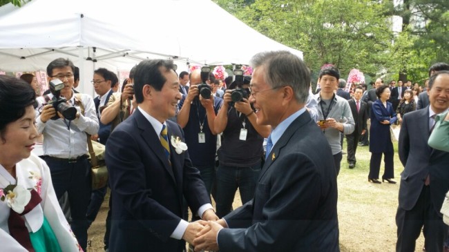 Rep. Moon Jae-in (right), the leader of the main opposition New Politics Alliance for Democracy, shakes hands with his fellow party member Rep. Chung Sye-kyun at a wedding ceremony for Chung’s son in the National Assembly complex on Sunday.   Yeo Jun-suk/The Korea Herald.