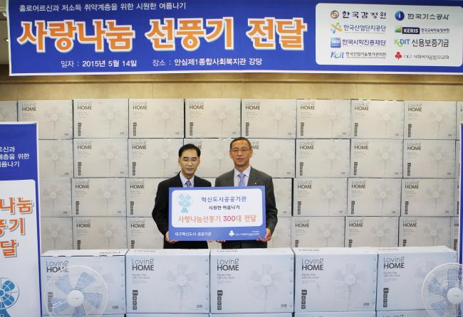 공공기관 사회공헌 협의회를 대표하여 김학규 한국감정원 상무이사(오른쪽)가 김오기 안심제일종합사회복지관장(왼쪽)에게 ‘사랑나눔 선풍기’ 300여대를 전달하고 있다.